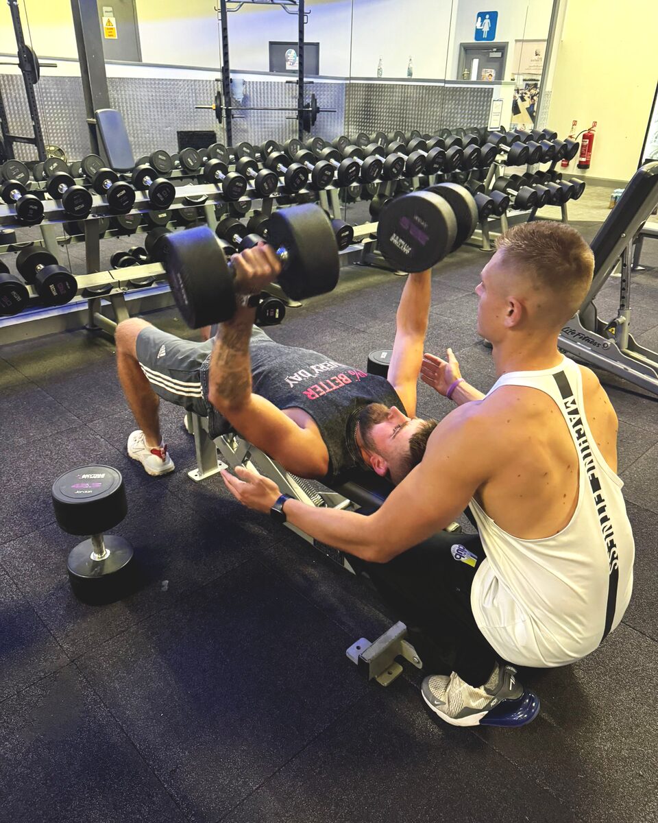 Personal trainer coaching correct lifting technique