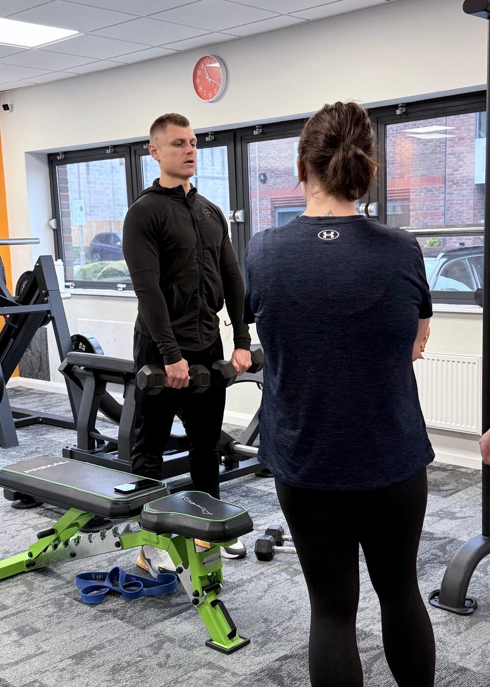 Personal training session coaching a bench press at the gym